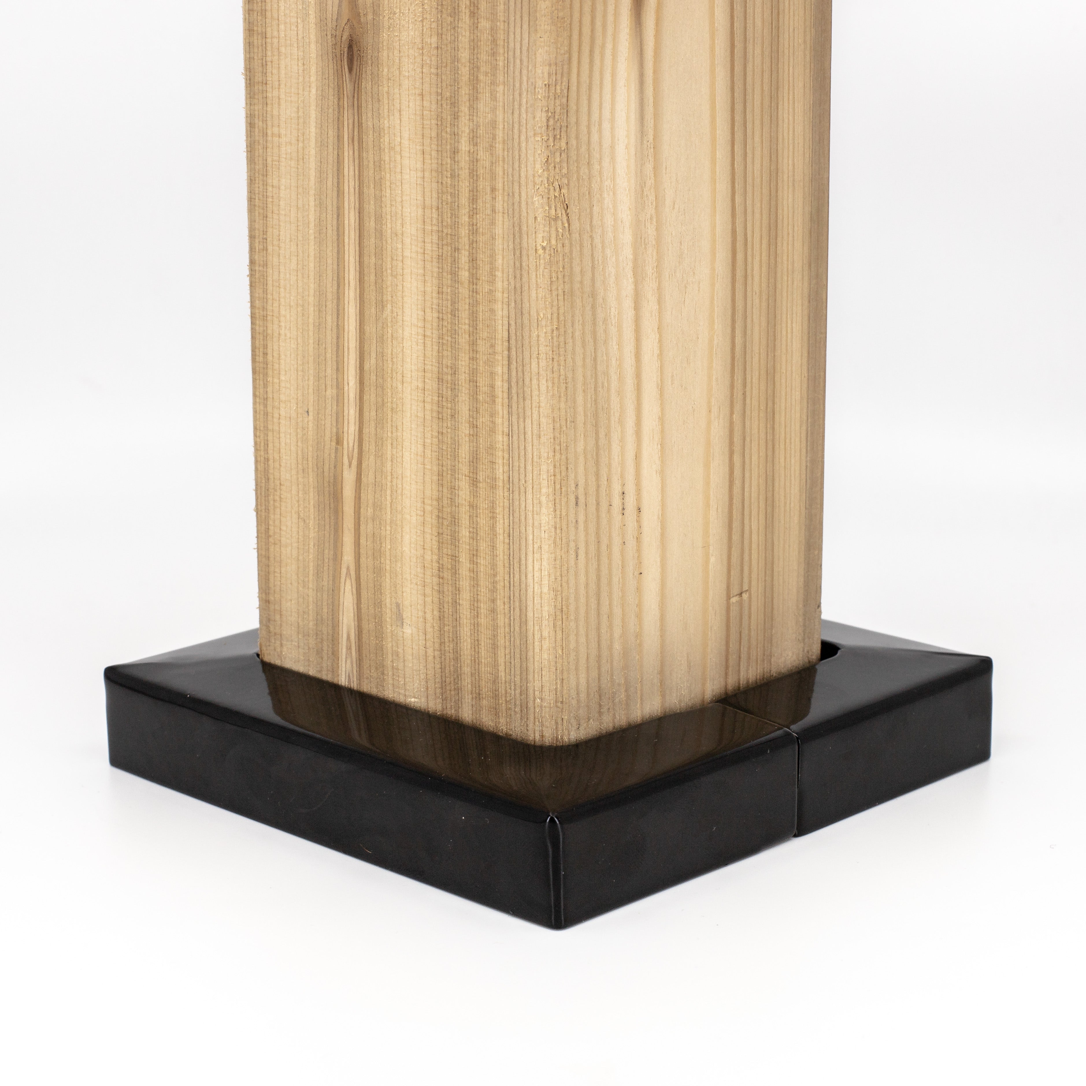 The 6x6 Double Bundle - White/Black features a Titan Wood Post Anchor that secures the wooden post on a glossy black base, highlighting the natural grain against the white surface. Zinc-coated metal post skirts add understated elegance.