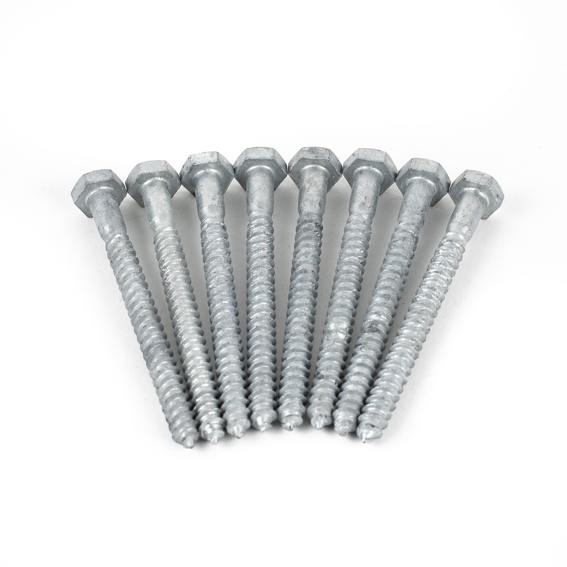Four shiny, galvanized 1/4x3 hex head lag screws are neatly aligned on a white background, threads facing forward, creating an even, symmetrical arrangement.