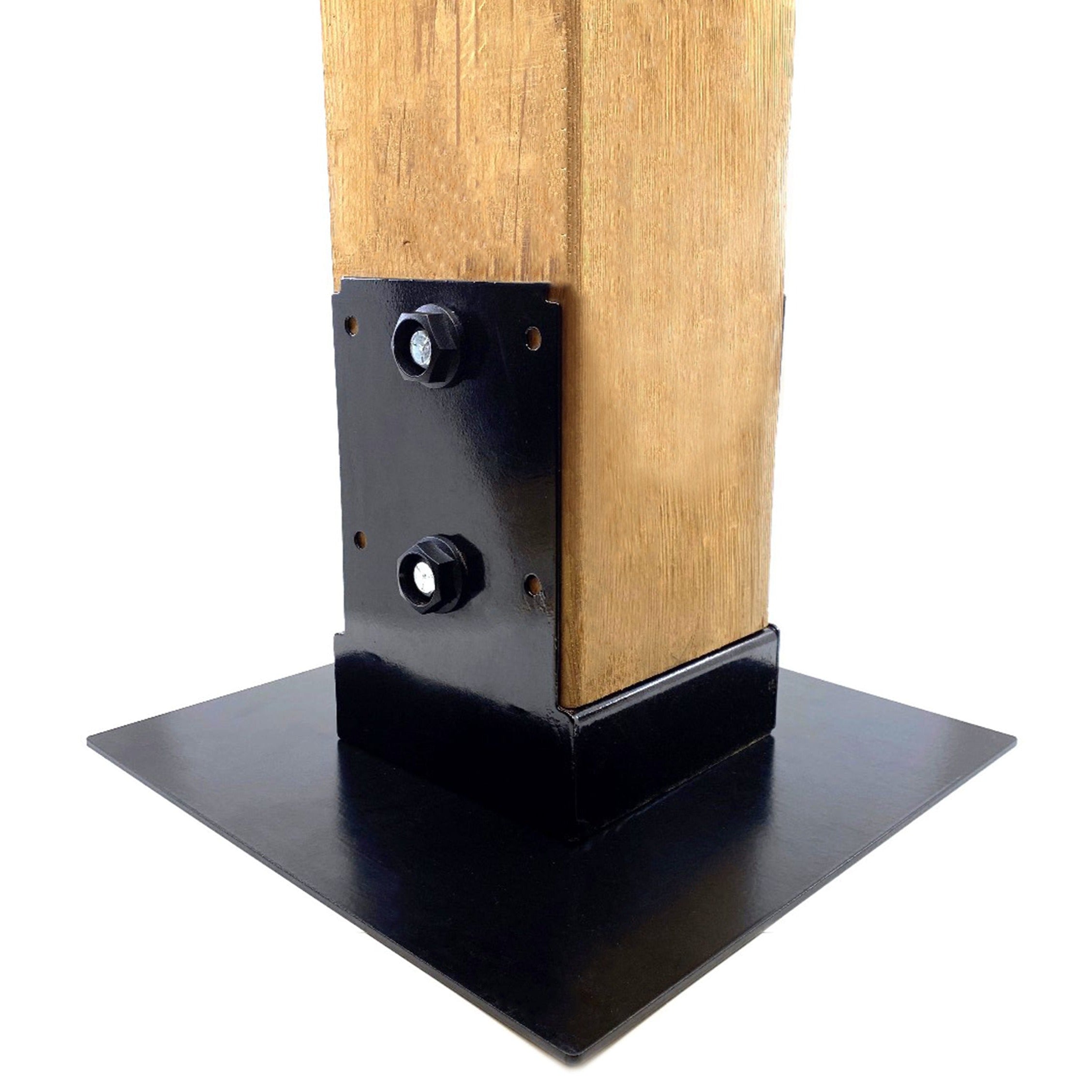 A wooden post is secured to a black metal baseplate using two T.C Bolts™ 6x6 (pair). The square, flat baseplate provides stability, perfect for pergola posts. The image features a plain white background.