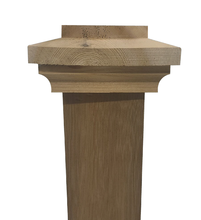 Wooden fence post topped with an Island Knotty Cedar Post Cap featuring a natural knotty cedar finish. The cap has a beveled edge, adding an ornate touch to the sturdy rectangular post.