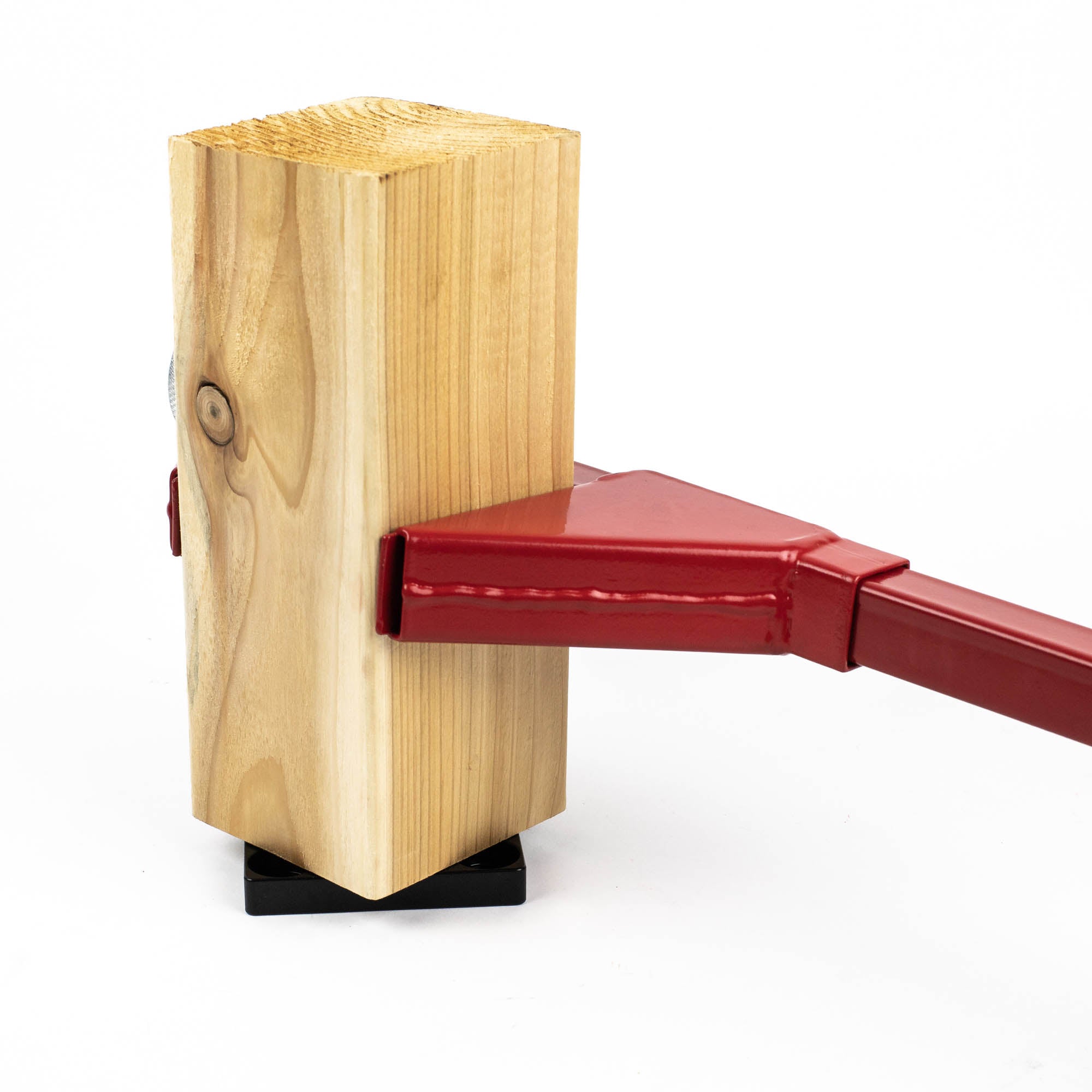The red metal Bad Boy Post Wrench securely holds a wooden block, showcasing its wood grain and knot, against a black base.