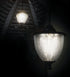 Two Classy Eclipse Solar Hanging Chandeliers adorn the decorative slatted wood ceiling, enhancing the outdoor decor. The nearest chandelier has an LED crackled glass cover, while the other is further away and dimmer, casting a soft glow in the dark.
