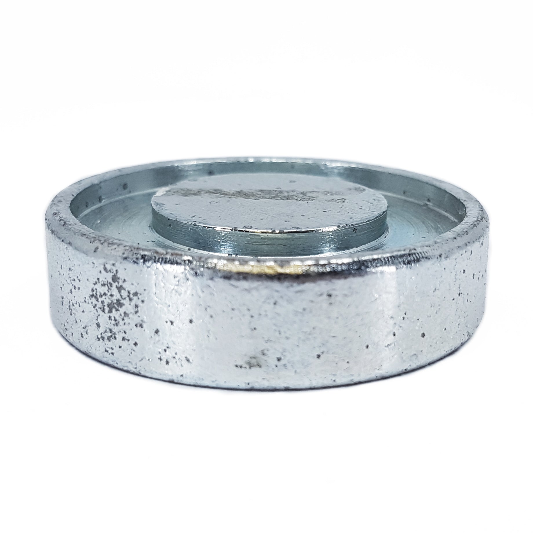 A Hammer Tool - 44, metallic and cylindrical with a rough surface and raised circular center, reminiscent of a builders tool, rests robustly against a white background akin to 4x4 post anchors.