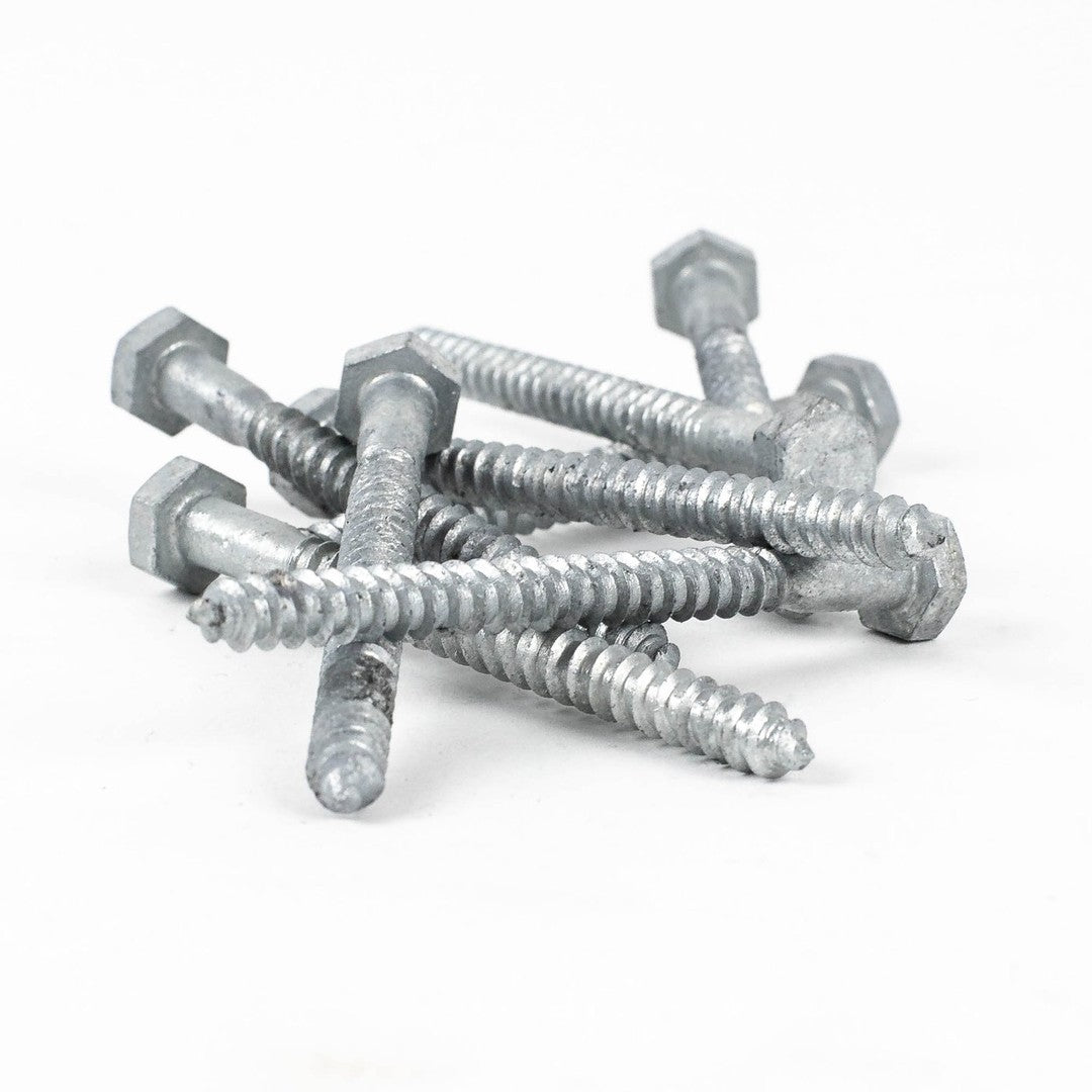 A pile of 1/4x3 Galv. Hex Head Lag Screws, featuring threaded bodies and pointed tips, is scattered on a white background.