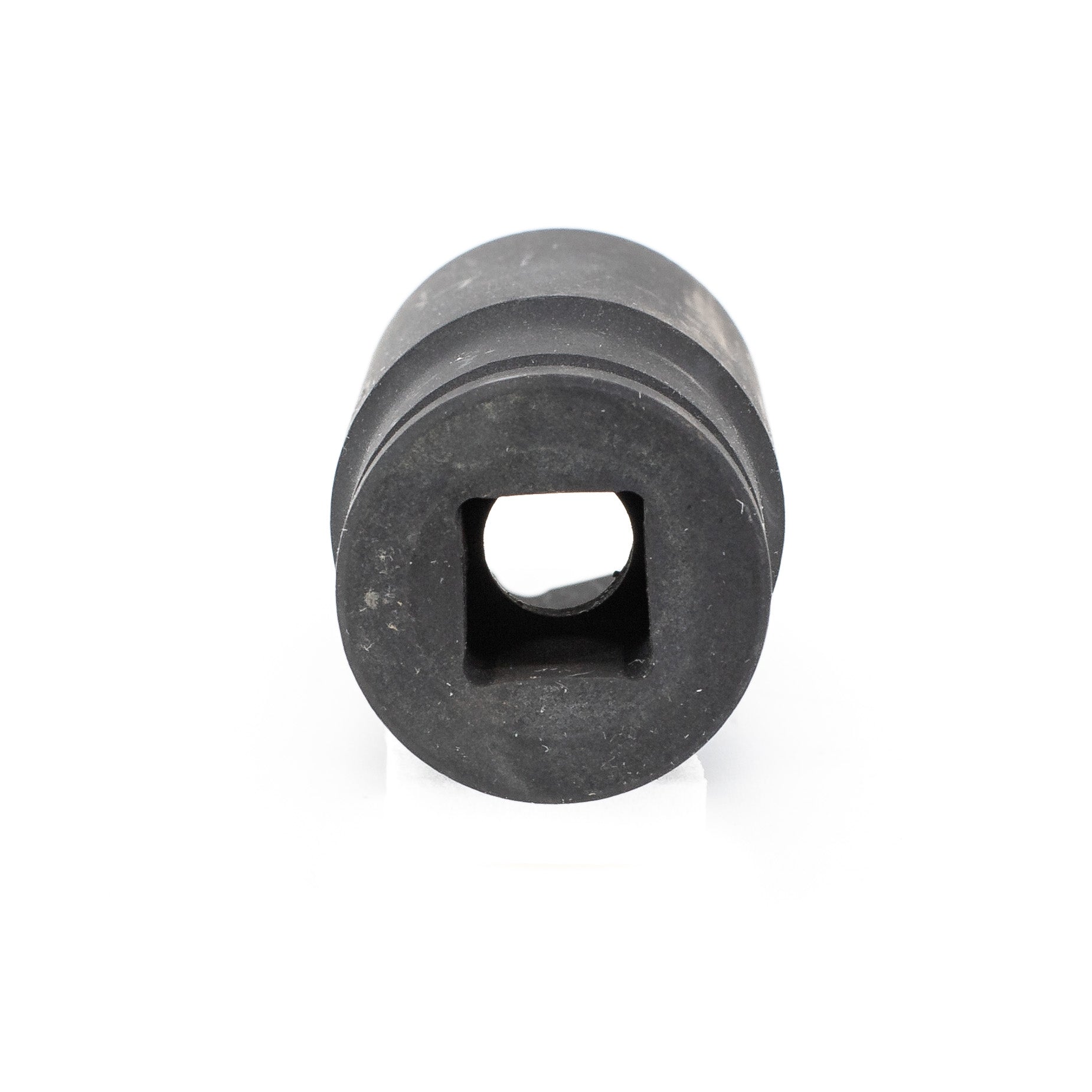 The Impact Socket is a black cylindrical object with a square hole in the center, made of durable Chrome Vanadium metal, featuring a matte finish. It is isolated on a white background, providing a direct view into its square opening, evoking professional Deep Impact Sockets.