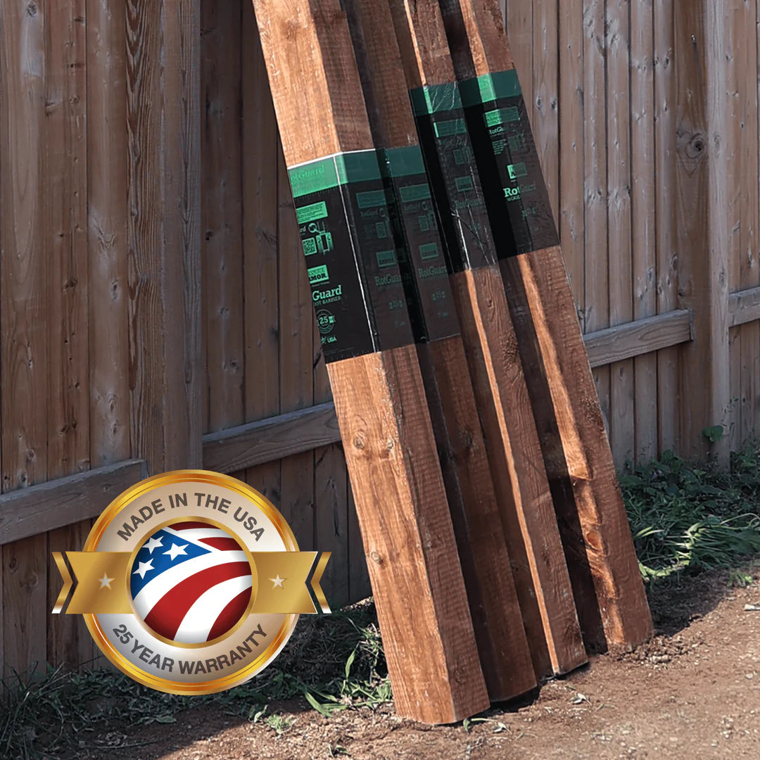 Wooden planks leaning against a wooden fence with 'Made in the USA' and warranty badge.