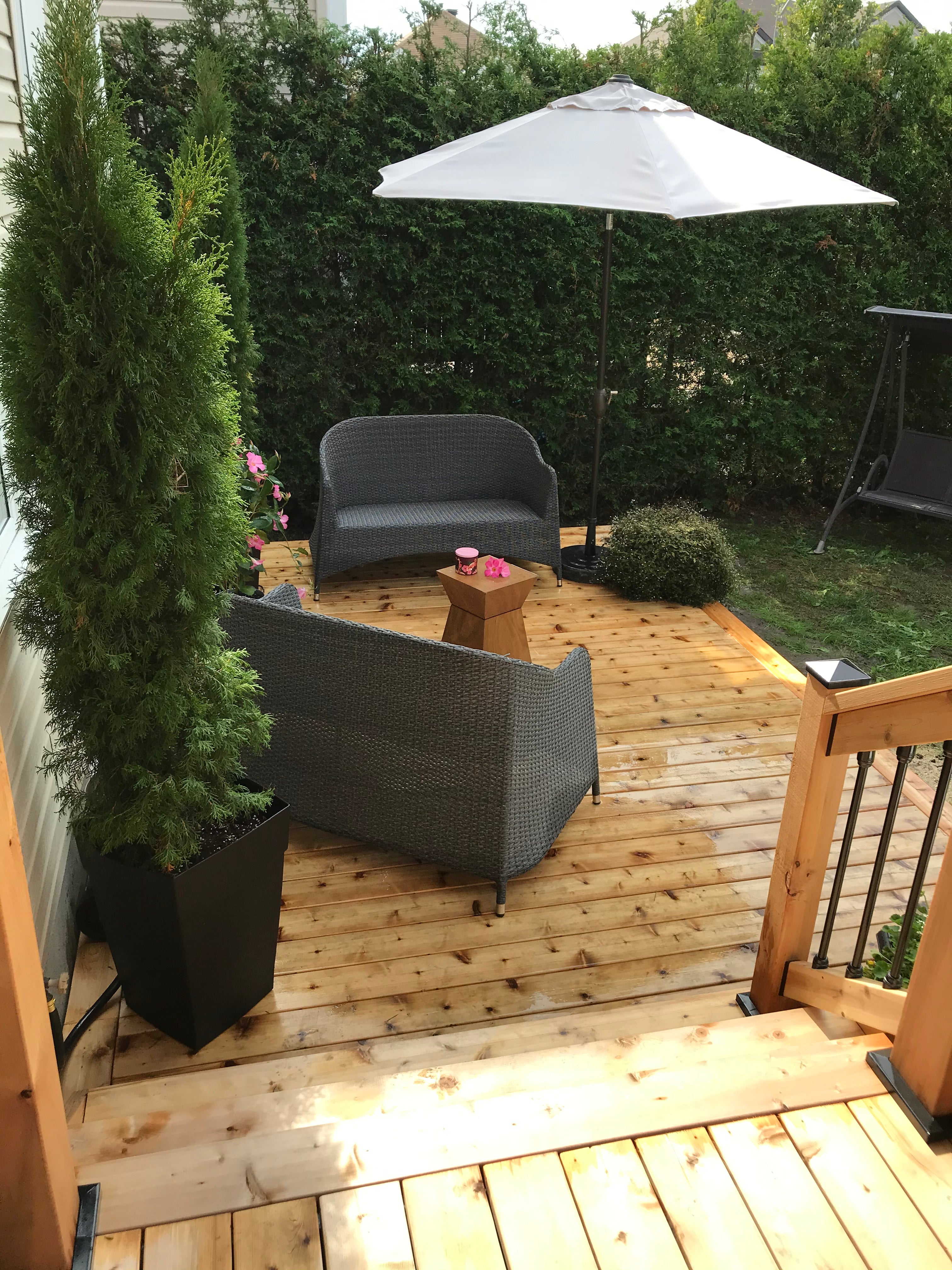 Outdoor patio with wooden deck, chairs, and umbrella