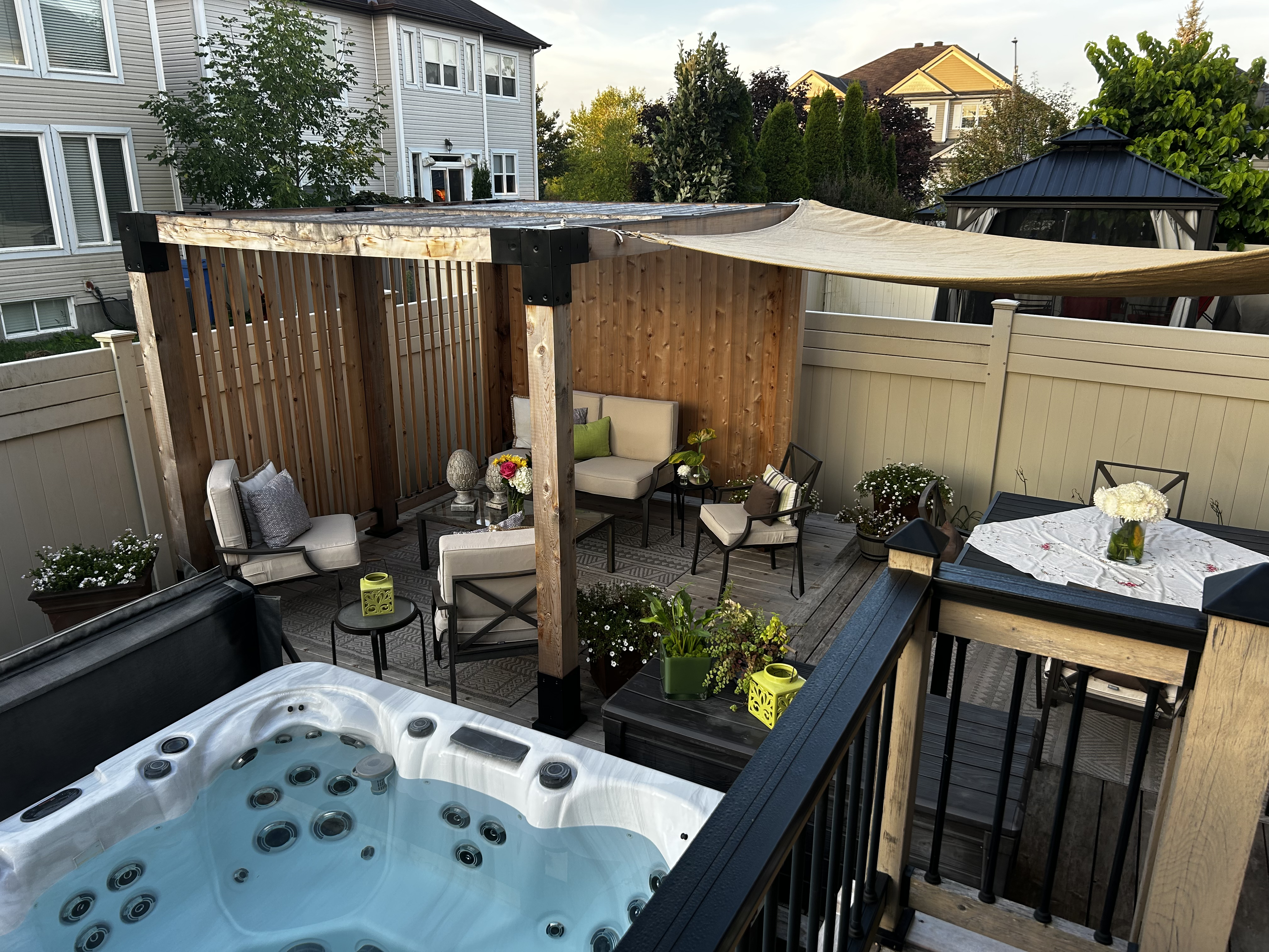 Outdoor hot tub area with seating and decor on a patio