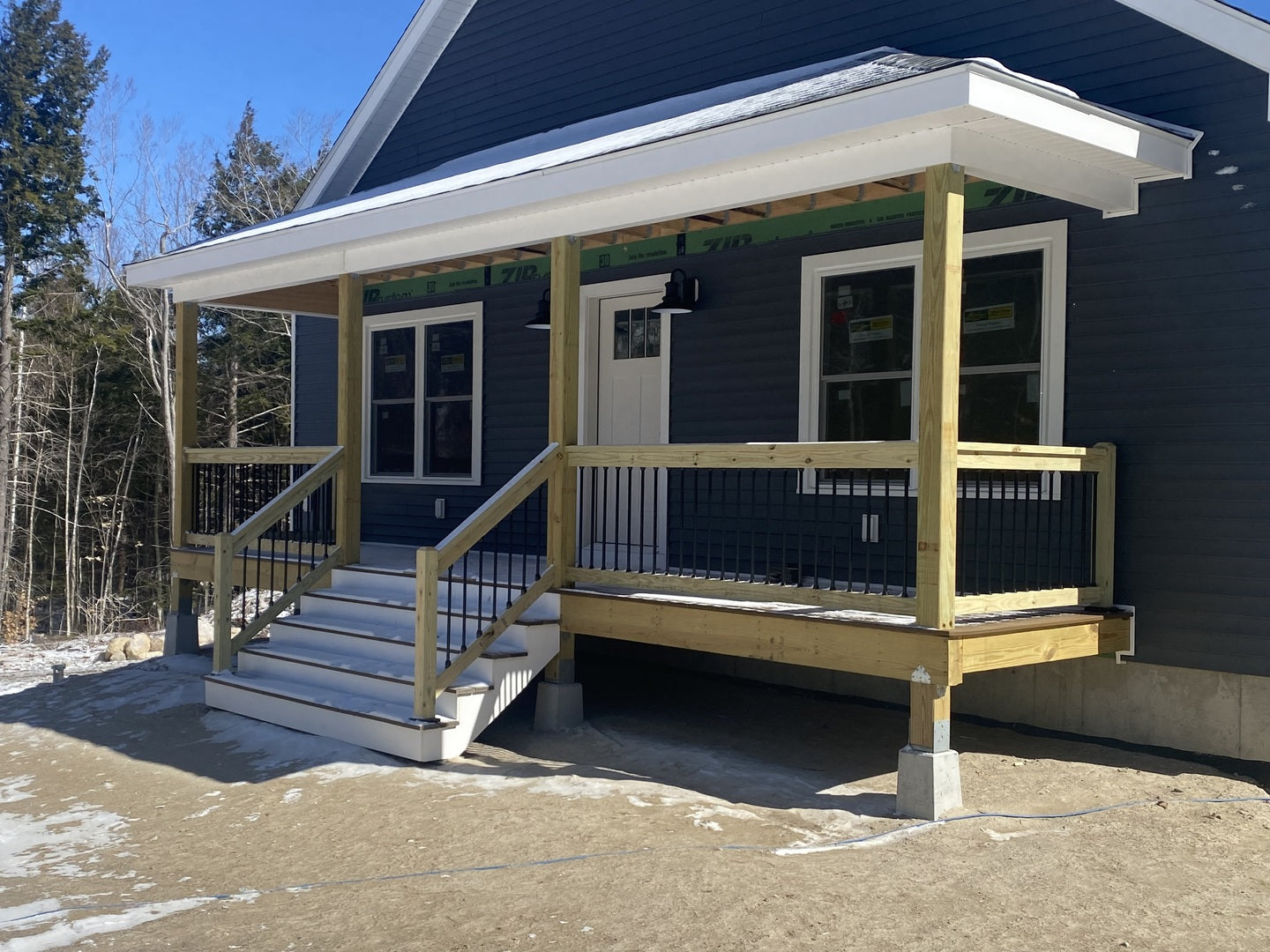 snap'n lock balusters on a porch with stairs attached to a blue house
